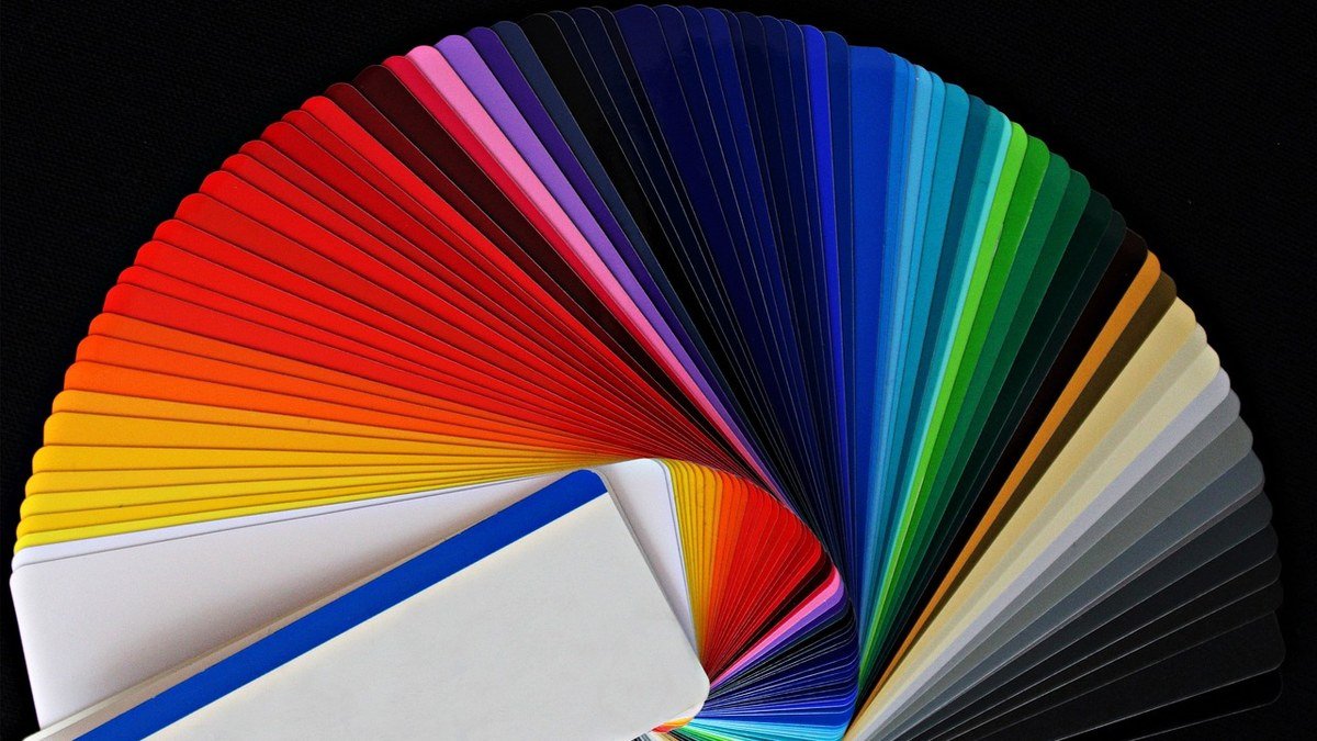 Fanned-out color swatches on a dark surface for Canva Craft