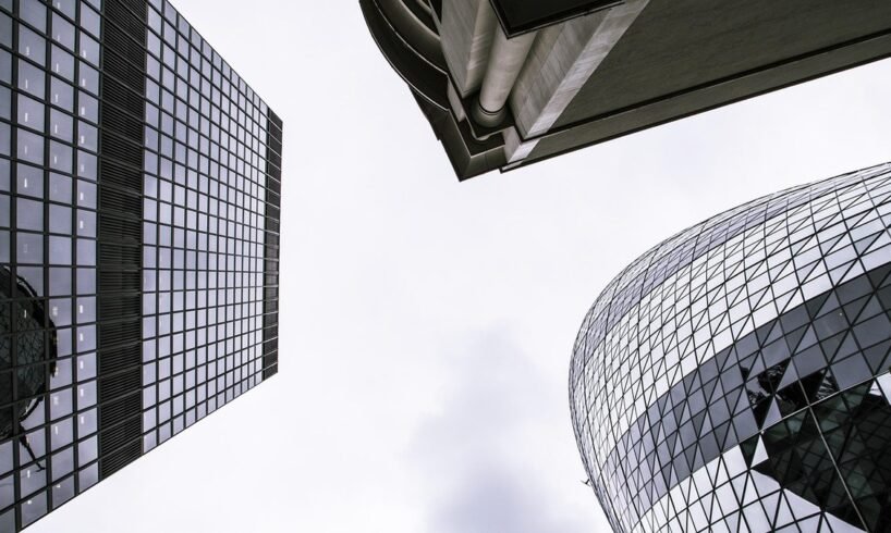 Glass office towers against a bright sky for an OpenAI funding round story