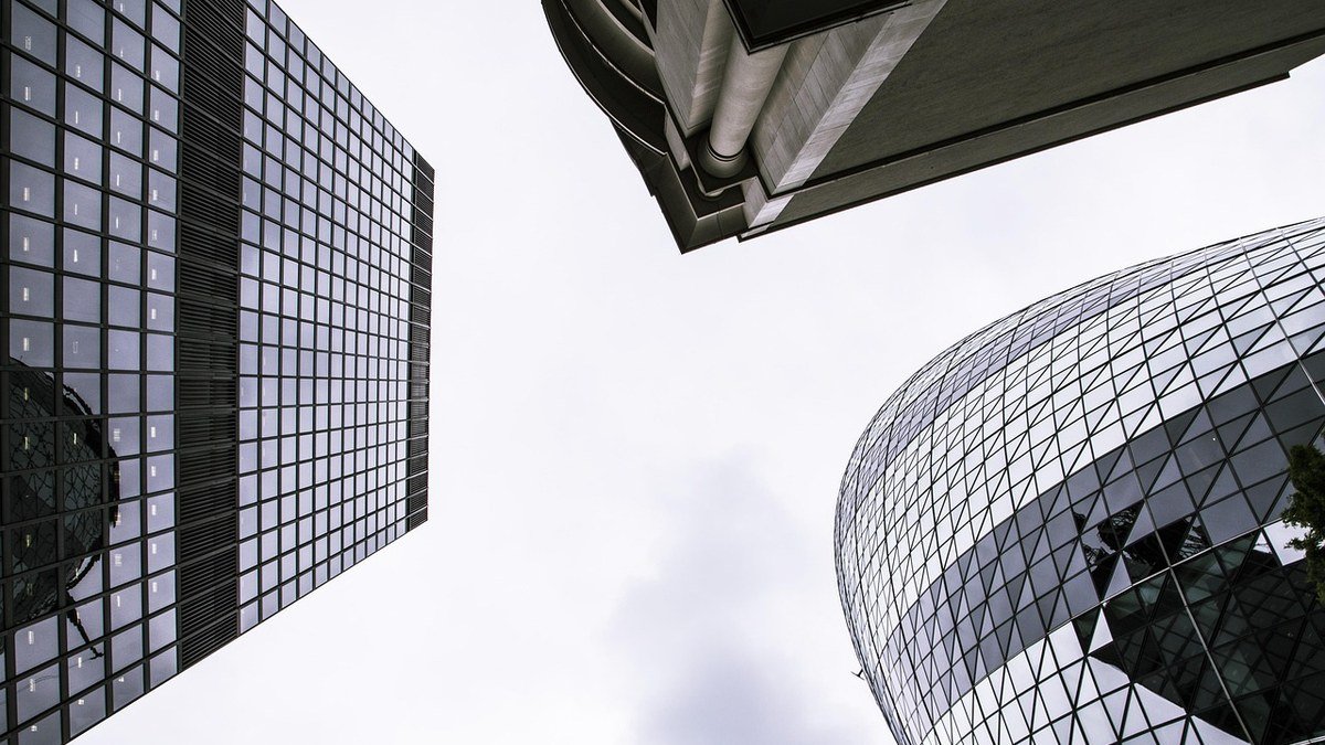 Glass office towers against a bright sky for an OpenAI funding round story
