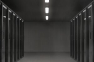 Corridor between rows of dark server racks in a data center, illustrating the computing infrastructure behind the reported OpenAI Google TPU purchase