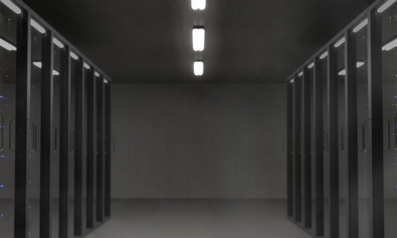 Corridor between rows of dark server racks in a data center, illustrating the computing infrastructure behind the reported OpenAI Google TPU purchase